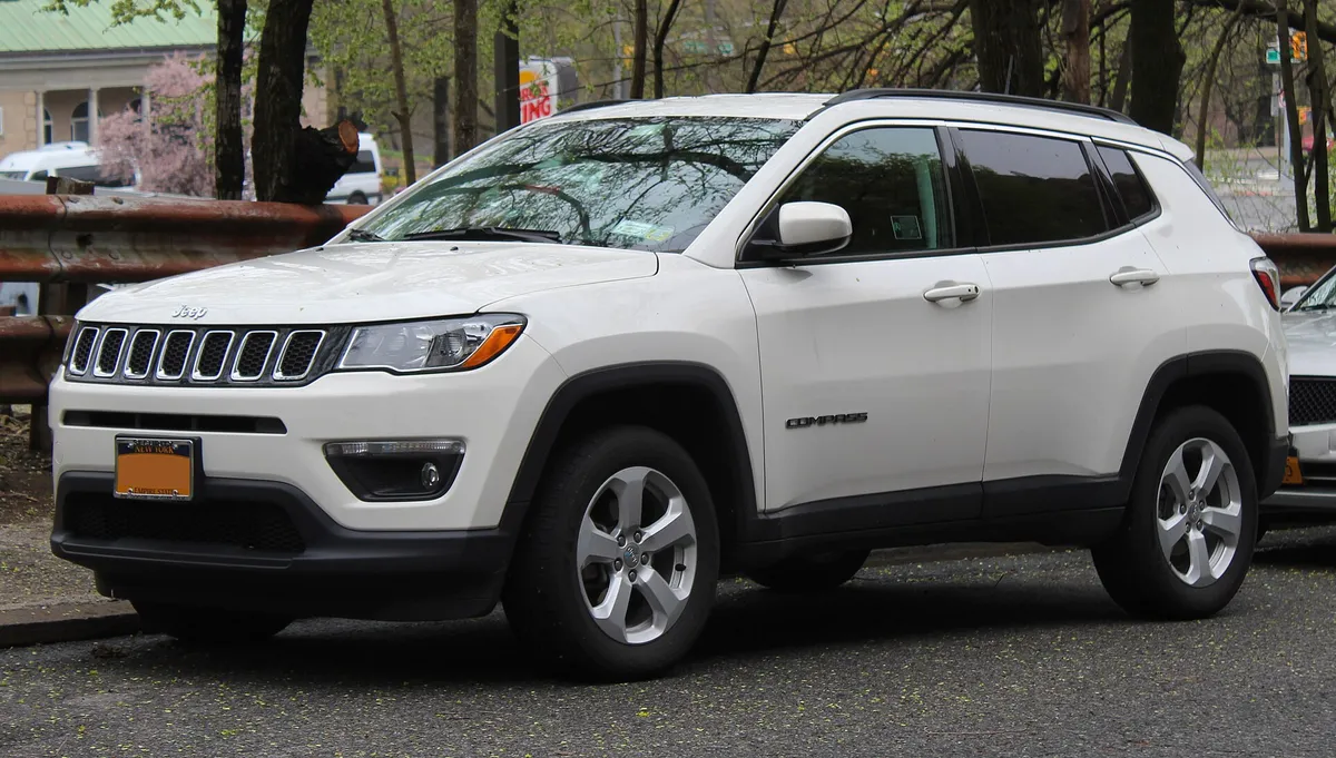 Jeep Compass branco, SUV médio, visto de frente e de lado
