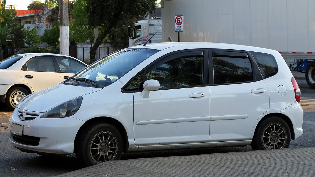 Honda Fit 1.4 LX 2008, primeira geração, hatch médio branco visto de frente e de lado
