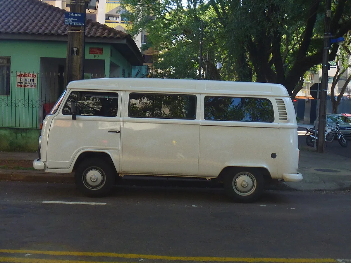 Volkswagen Kombi branca da geração clipper, vista de lado, estacionada na rua