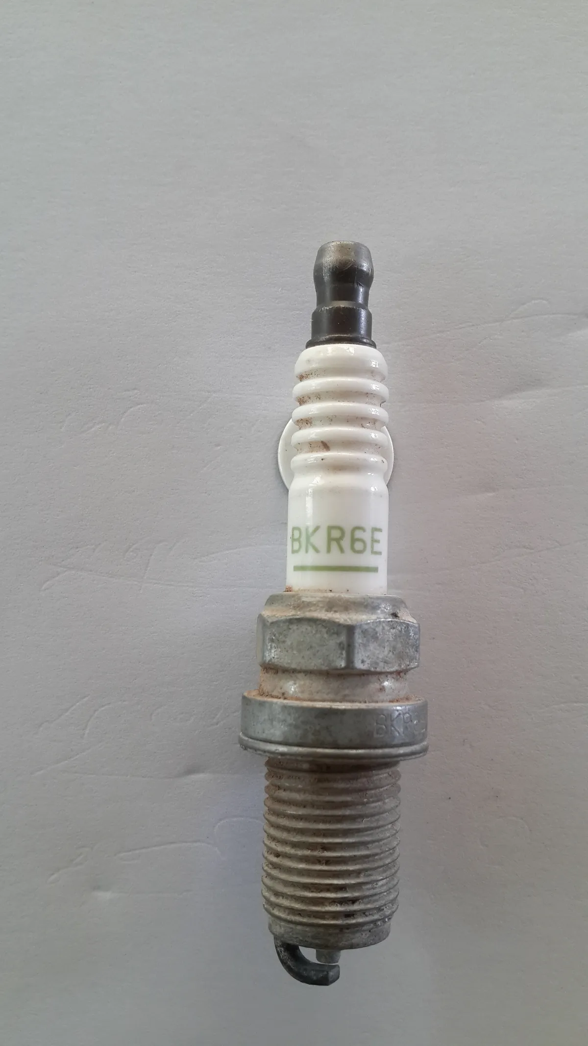 Vela de ignição de carro em detalhe, mostrando o eletrodo e a rosca